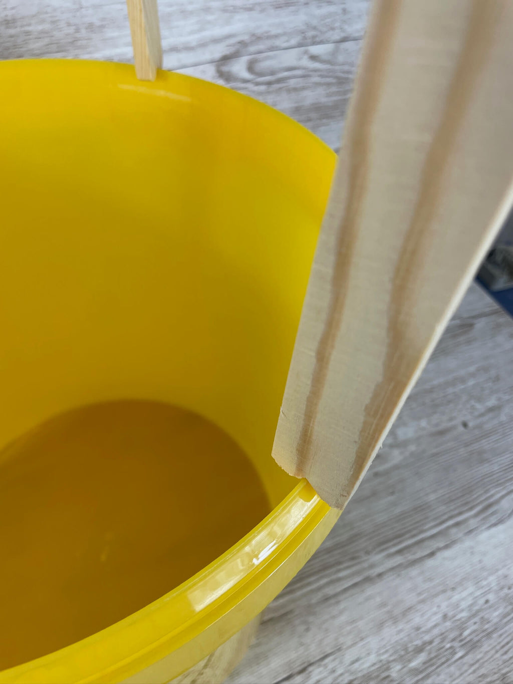 Detailansicht des ApiNord Dreibein Stativ beim Einsatz über einem Kübel. Es zeigt die Auflage auf dem Honigeimer.