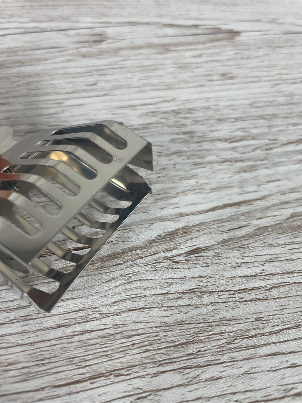 Detailansicht des geöffneten Metall-Abfangclips mit Sicht auf die abgerundeten Greifkanten.