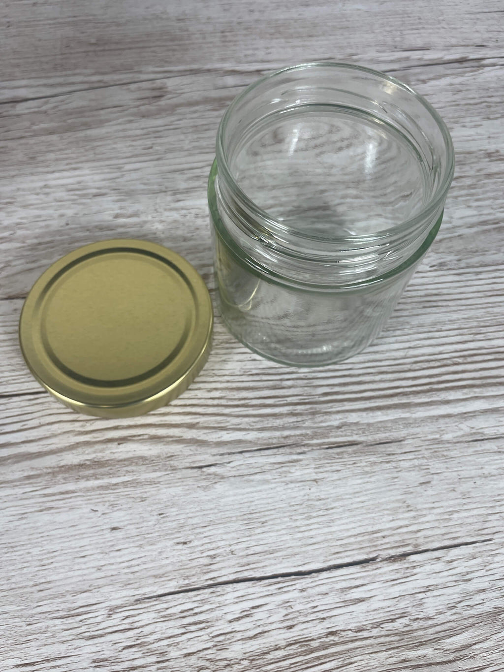 Leeres Deep Rundglas 415 ml in der Draufsicht mit links danebenliegendem goldenem Deep-Schraubdeckel